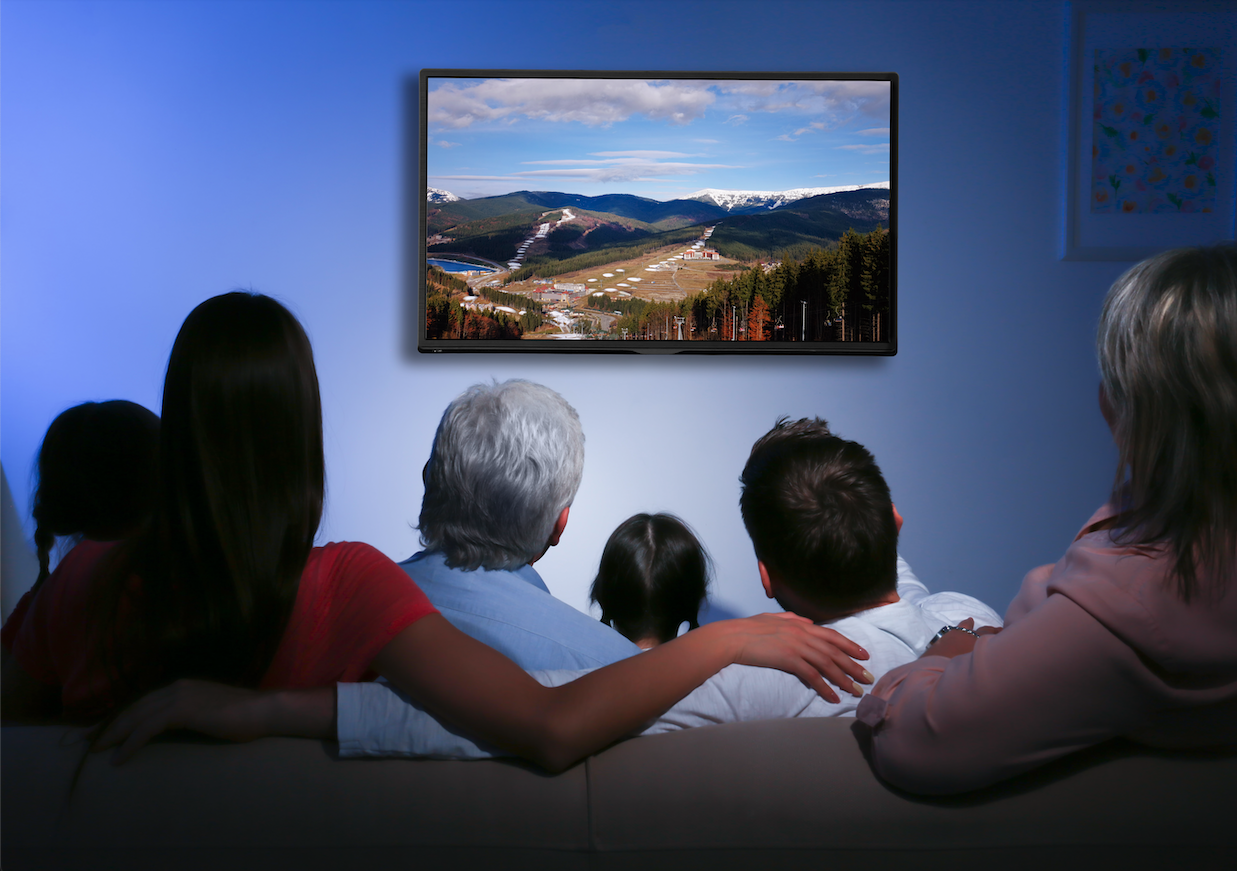 a multi-generational family watches a TV together