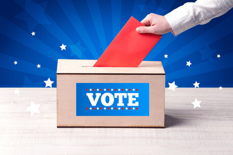 Voting hand with ballot and wooden box