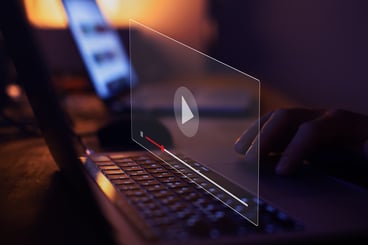 A person uses their laptop to streaming online video content