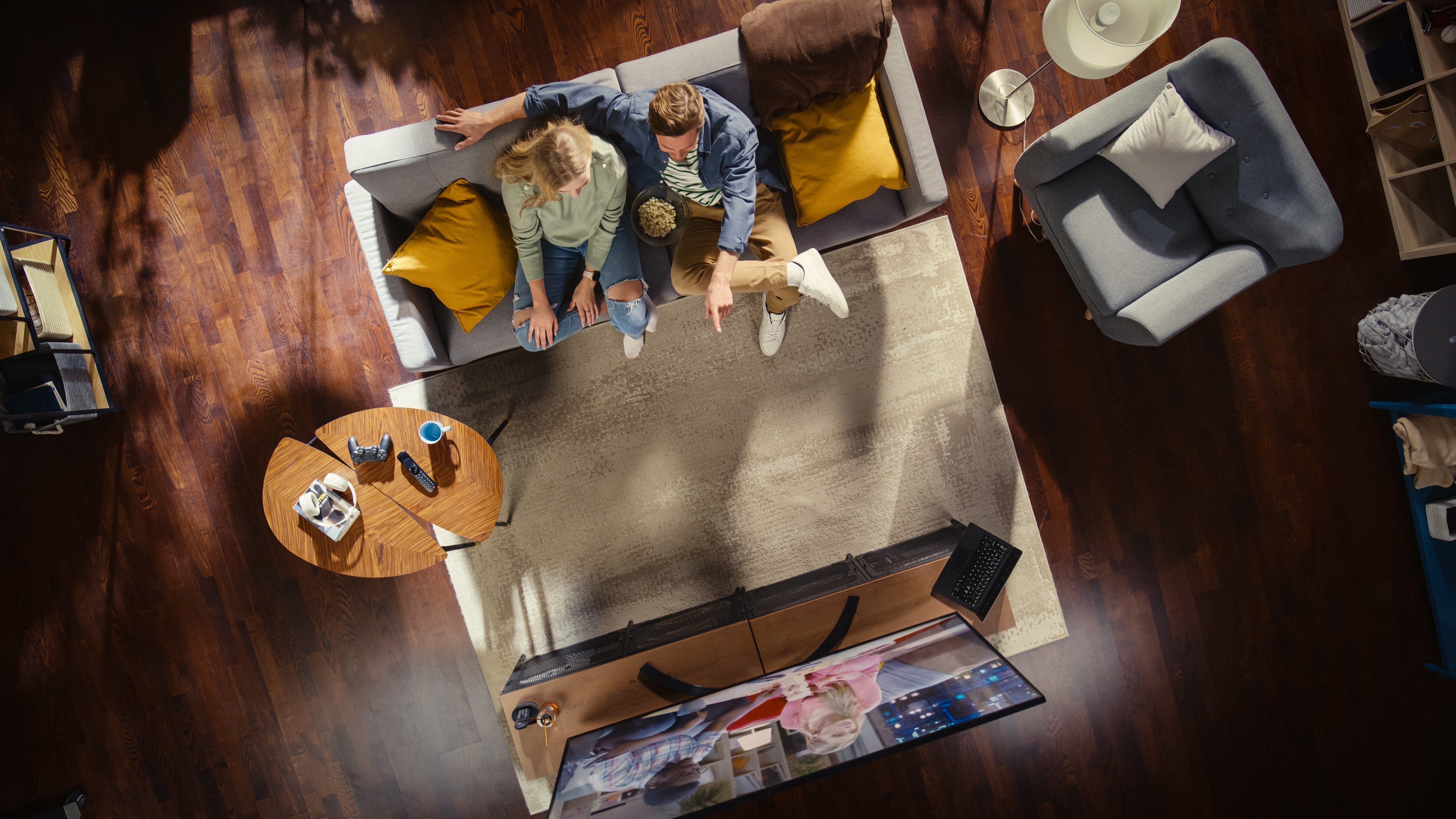 a top down view of a couple sitting on their couch watching television