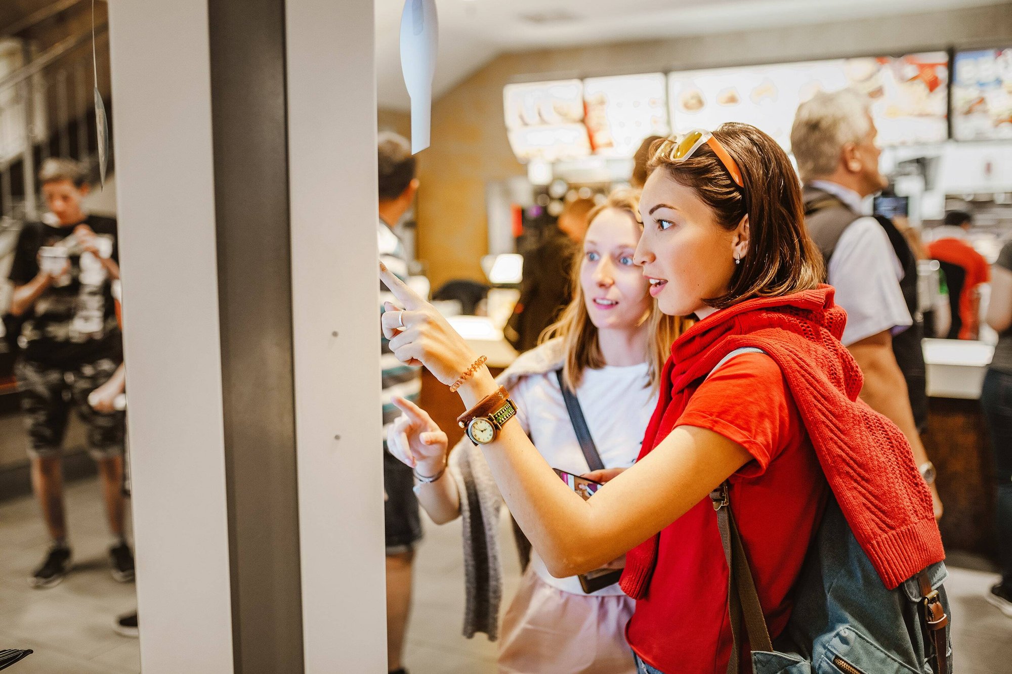 two woman ordering from a fast food restaurant