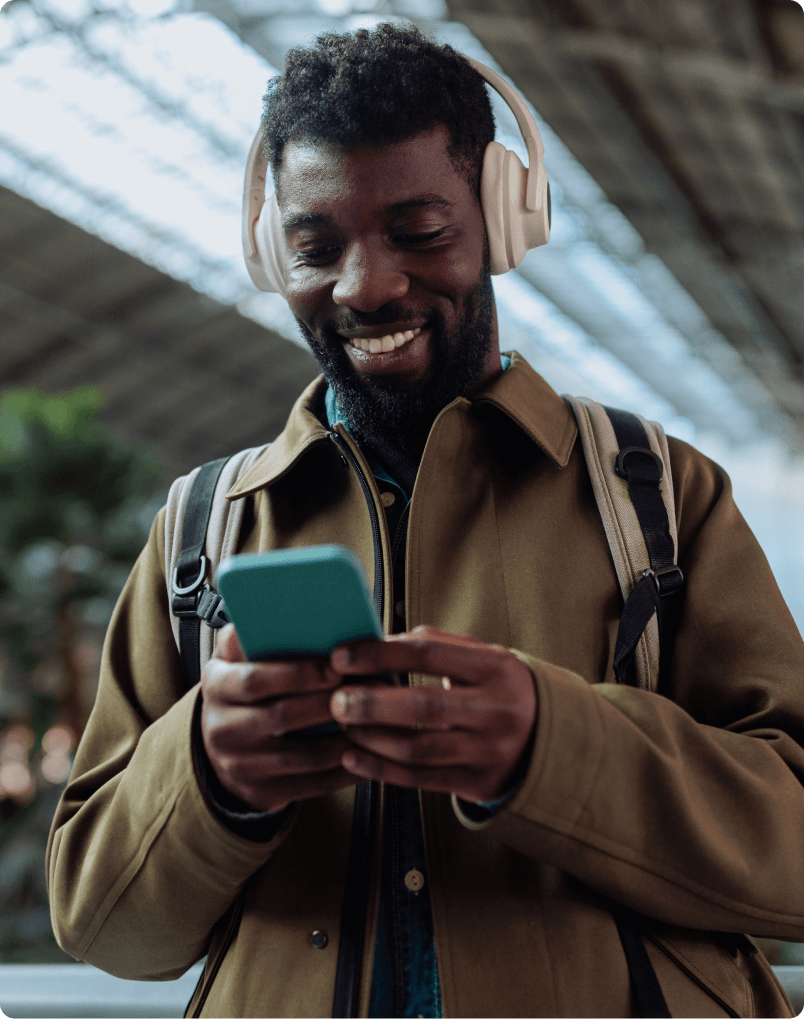 african american man listening to podcast with headphones in the airport 