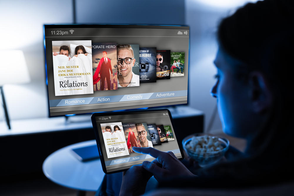 a person browses OTT services on a tablet and smart TV