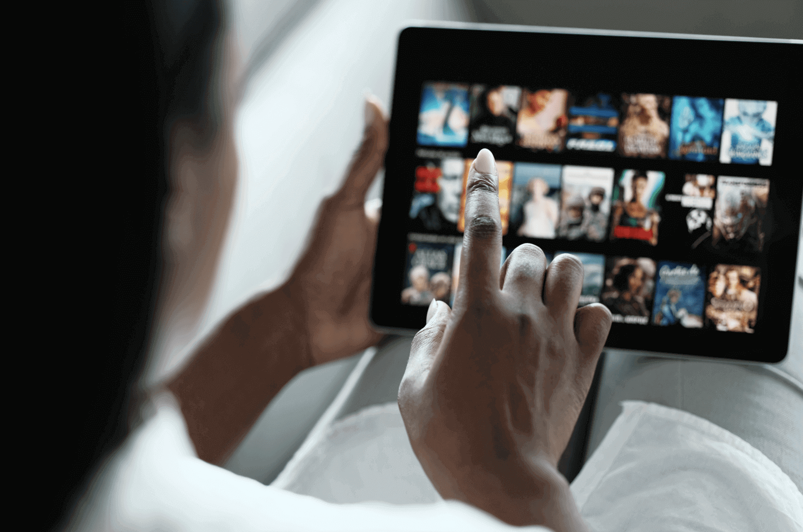a woman presses her tablet that shows different streaming tv options
