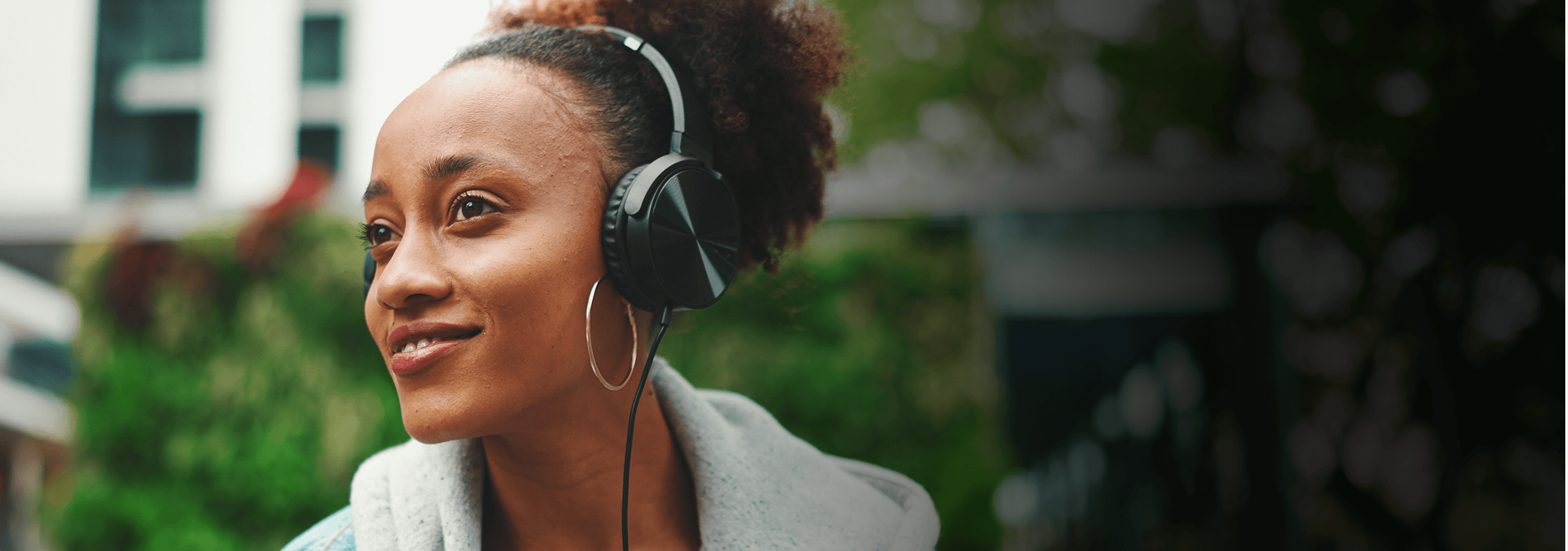 african american woman listening to podcast with wired headphones