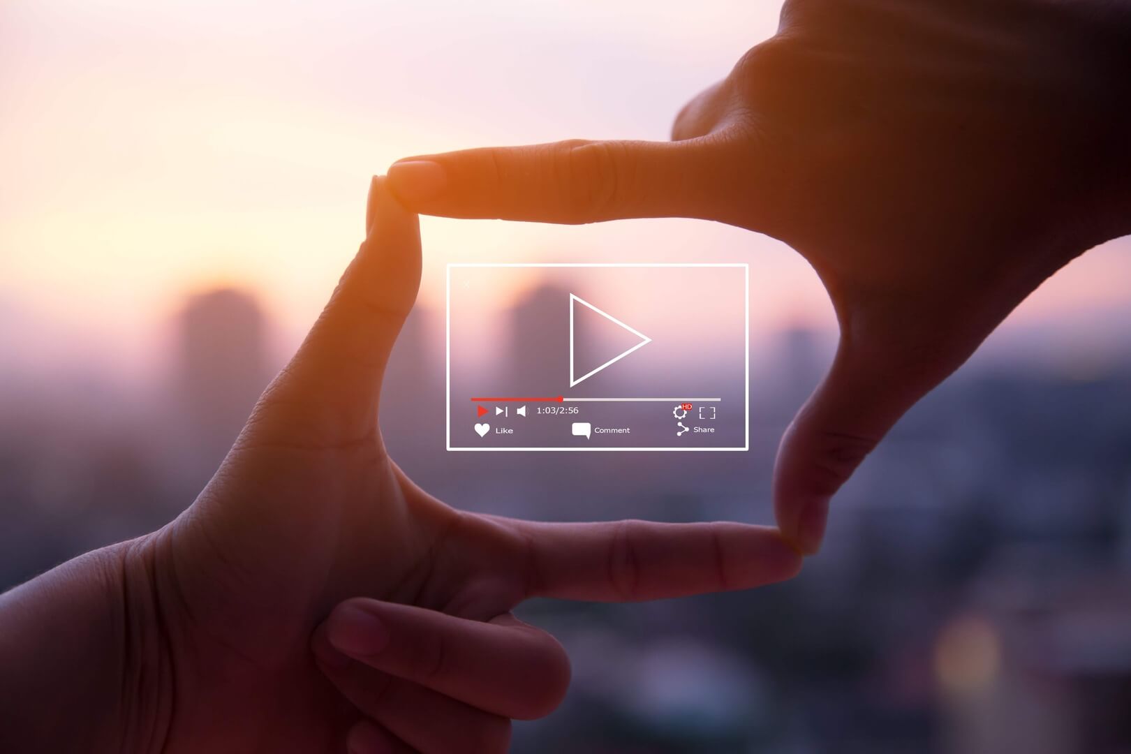 two hands forming a square around a video streaming outline against a city scape background