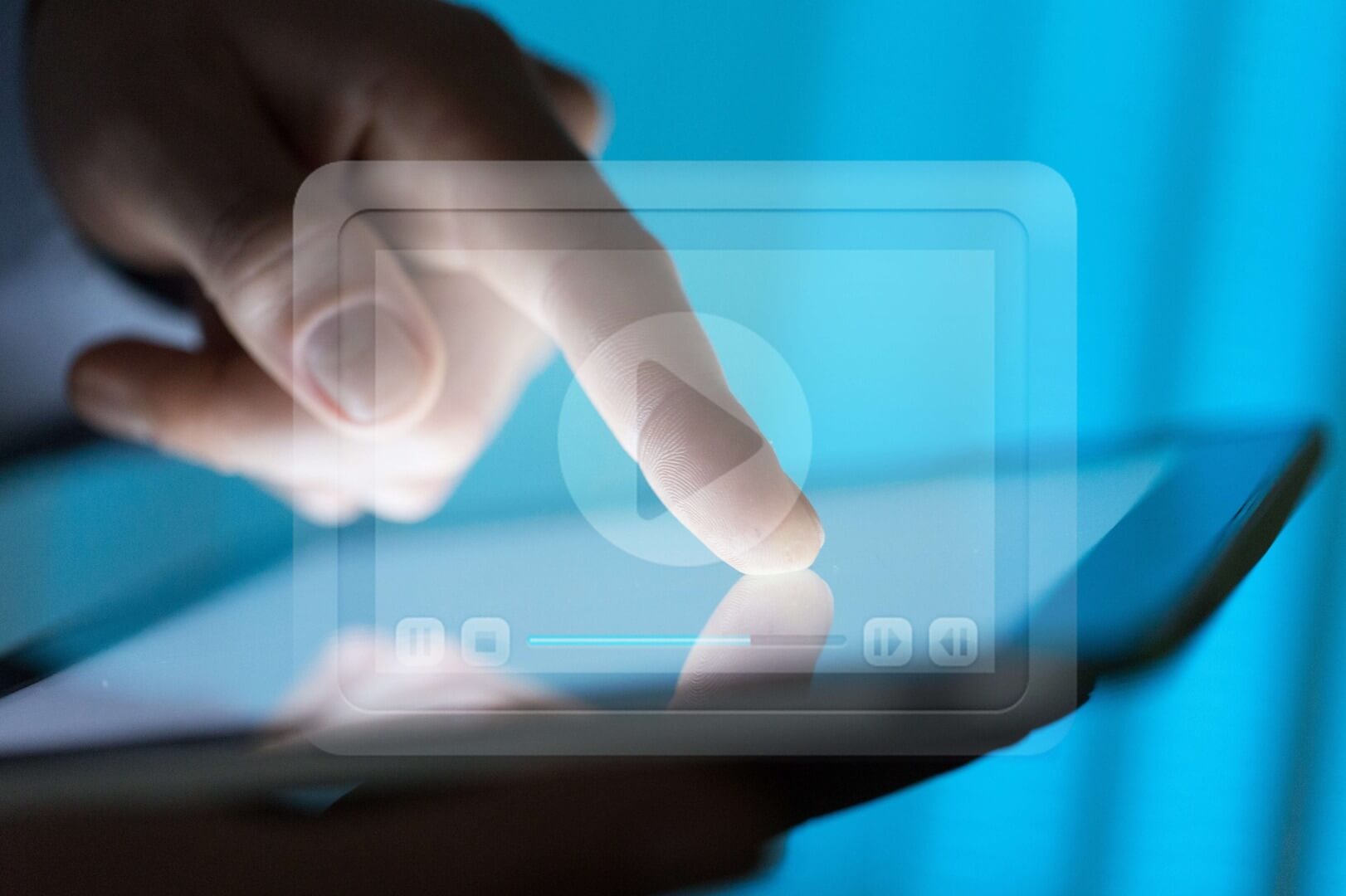 a finger touches the screen of a tablet behind a video streaming interface