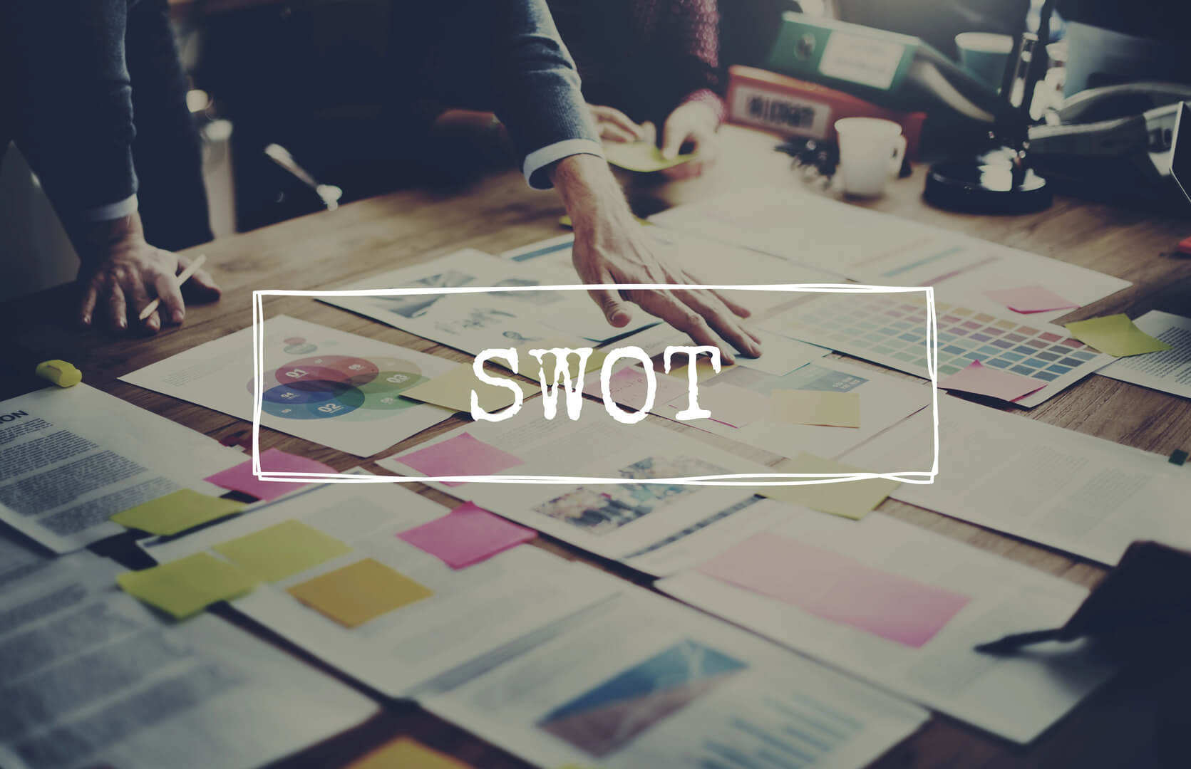 SWOT overlays a desk of papers and documents